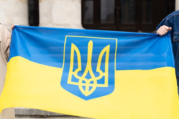 Vue de face personnes tenant le drapeau ukrainien