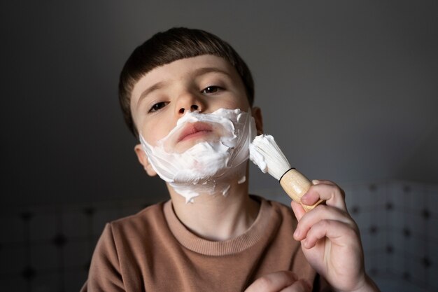 Vue de face petit enfant utilisant de la crème à raser