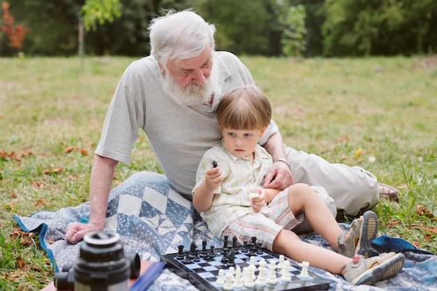 Vue de face petit-fils assis avec grand-père