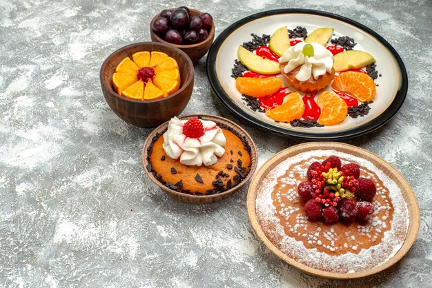 Vue de face petit gâteau crémeux avec gâteau aux framboises et tarte sur fond blanc gâteau aux fruits biscuit sucré tarte au sucre