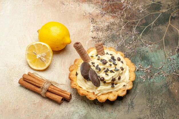 Vue de face petit gâteau délicieux avec de la crème sur le fond clair