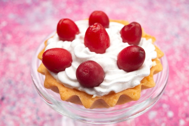 Photo gratuite vue de face petit gâteau délicieux avec de la crème et des fruits rouges sur la surface lumineuse sucrée