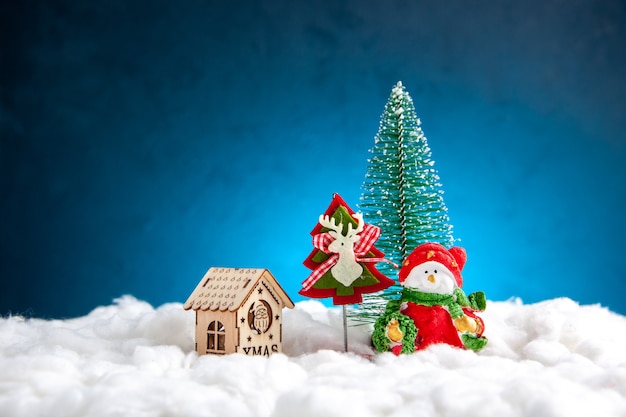 Vue de face petite maison en bois de jouets de Noël sur fond bleu