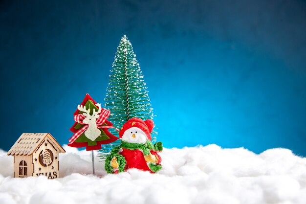 Vue de face petite maison en bois de jouets de Noël sur fond bleu