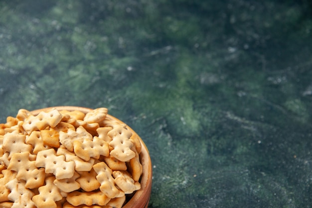 Vue de face de petits craquelins à l'intérieur de la plaque sur le fond sombre snack croustillant pain de sel biscotte nourriture cips couleur