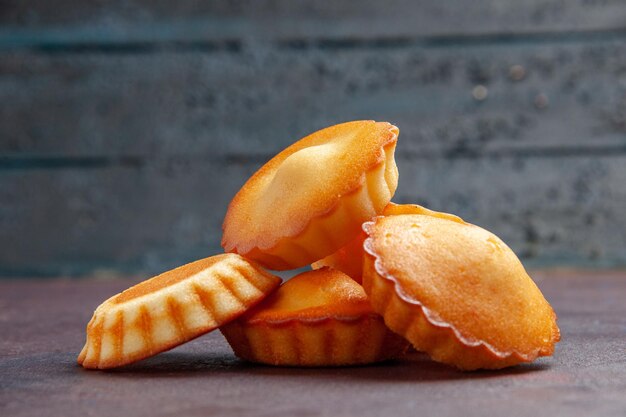 Vue de face de petits gâteaux délicieux sur fond sombre tarte biscuit gâteau biscuit sucré thé au sucre