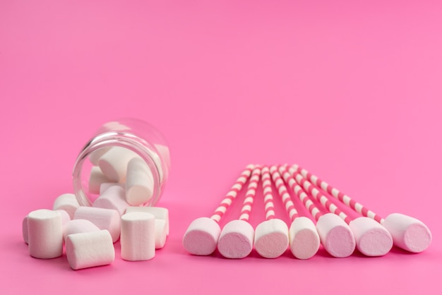 Une vue de face peu de guimauves blanches, avec des bâtons et à l'intérieur peut sur rose, sucre sucré bonbons de confiserie