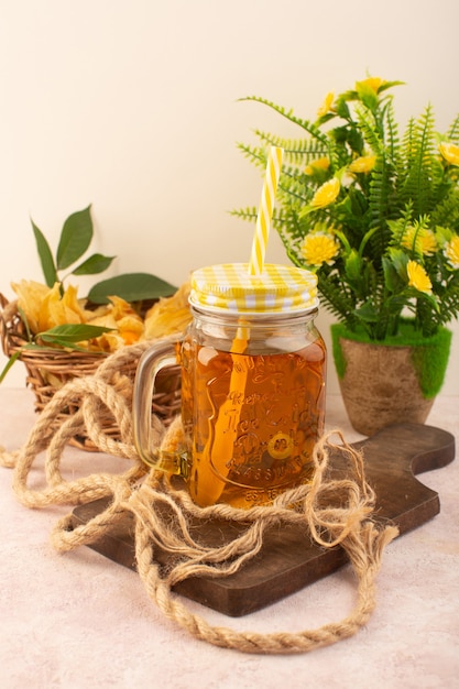 Une vue de face physalises pelées orange à l'intérieur du panier avec un cocktail sur le bureau rose