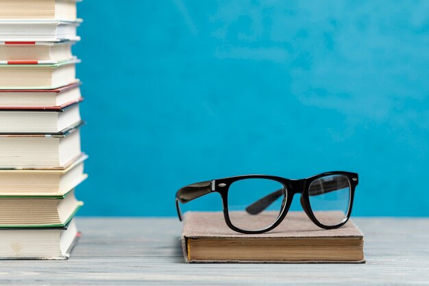 Vue de face pile de livres avec des lunettes