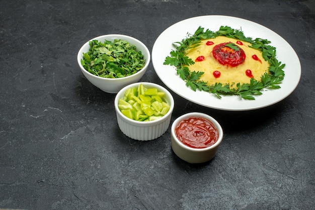 Vue de face plat de pommes de terre en purée avec sauce tomate et légumes verts sur l'espace sombre