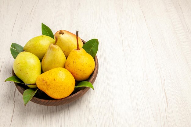 Vue de face poires douces fraîches fruits sucrés à l'intérieur de la plaque sur le bureau blanc fruit jaune frais sucré mûr