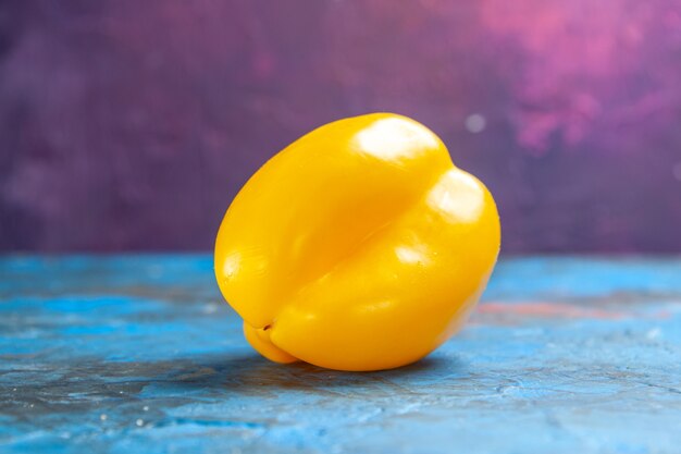 Vue de face poivron jaune sur la table bleu-rose