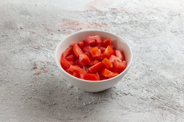 Vue de face poivron tranché à l'intérieur de la petite assiette sur une surface claire