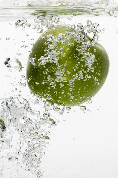 Vue de face de la pomme verte dans l'eau