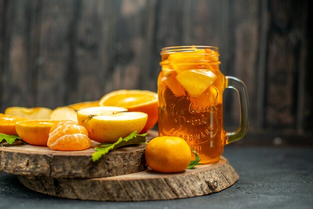 Vue de face des pommes oranges coupées en cocktail sur fond sombre
