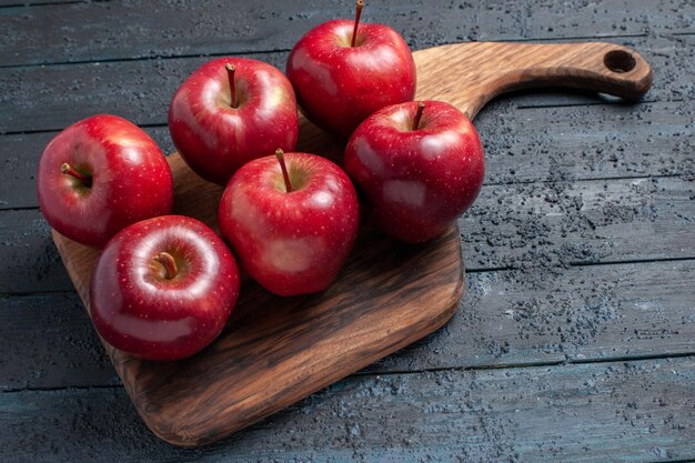 Vue de face pommes rouges fraîches fruits mûrs moelleux sur bureau bleu foncé fruits couleur rouge plante vitamine frais