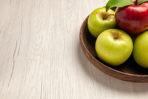 Vue de face pommes vertes fraîches fruits mûrs et moelleux sur un bureau blanc fruits couleur arbre plante fraîche rouge