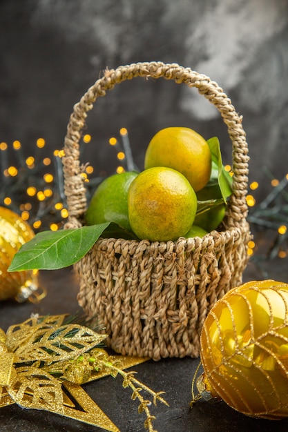 Vue de face des pommes vertes fraîches avec des mandarines sur fond sombre photo couleur fruits de vacances de Noël