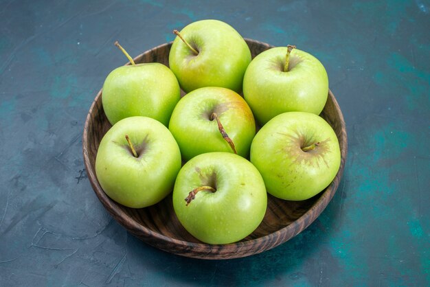 Vue de face les pommes vertes fraîches et moelleuses sur bureau bleu foncé fruit plante fraîche arbre moelleux