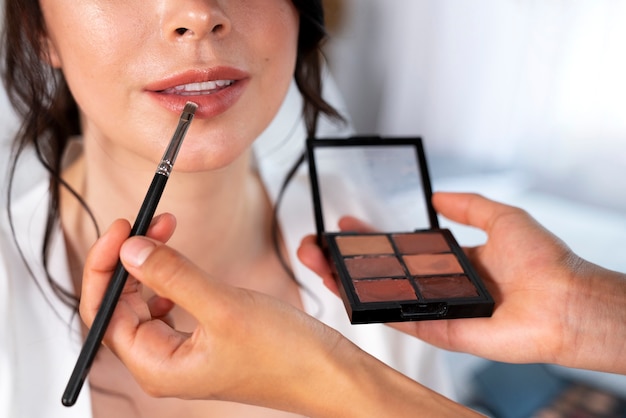 Vue de face professionnelle faisant un maquillage de mariée