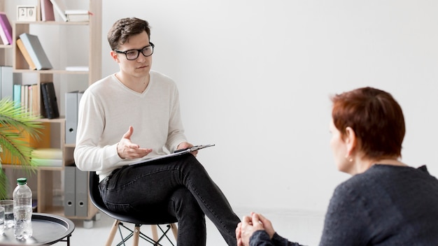 Vue de face d'un psychologue consultant un patient