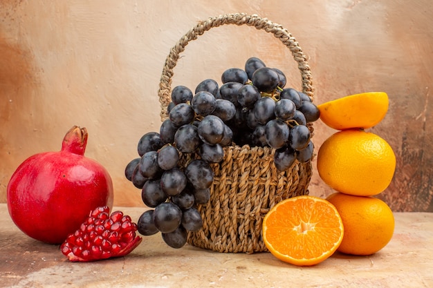 Vue de face raisins noirs frais avec orange sur fond clair arbre photo moelleux fruits mûrs vitamine