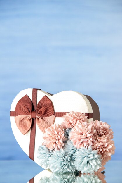 Photo gratuite vue de face saint valentin présent avec des fleurs sur fond bleu clair couleur amour passion couple sentiment famille beauté coeurs