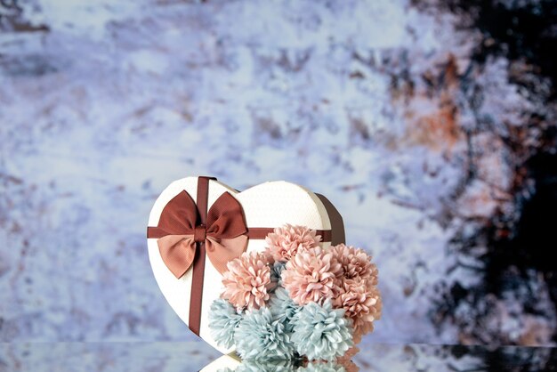 Vue de face Saint Valentin présent avec des fleurs sur fond clair sentiment famille beauté couple passion amour coeur