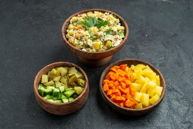 Vue de face salade mayyonaise avec des légumes tranchés sur une surface grise repas salade collation déjeuner