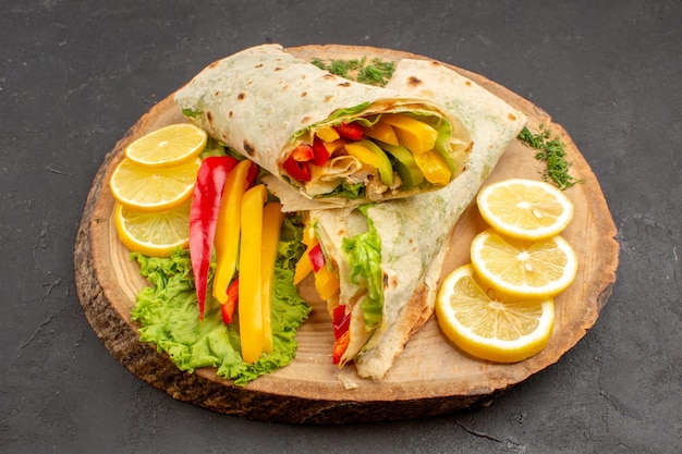 Vue de face sandwich à la viande savoureuse shaurma en tranches avec des tranches de citron sur l'espace sombre