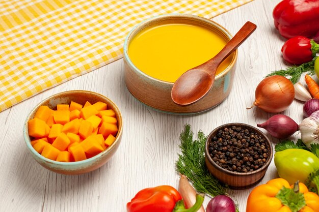 Vue de face savoureuse crème de soupe à la citrouille texturée avec des légumes sur un bureau blanc plat de soupe mûr sauce repas