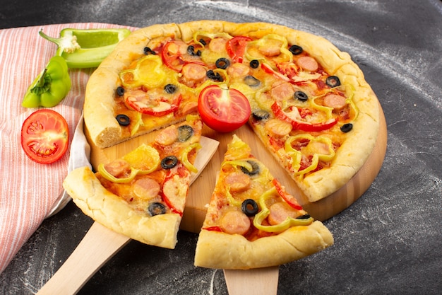 Vue de face savoureuse pizza au fromage avec tomates rouges olives noires poivrons et saucisses sur gris