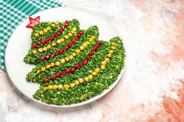 Vue de face savoureuse salade verte en forme d'arbre du nouvel an sur fond clair