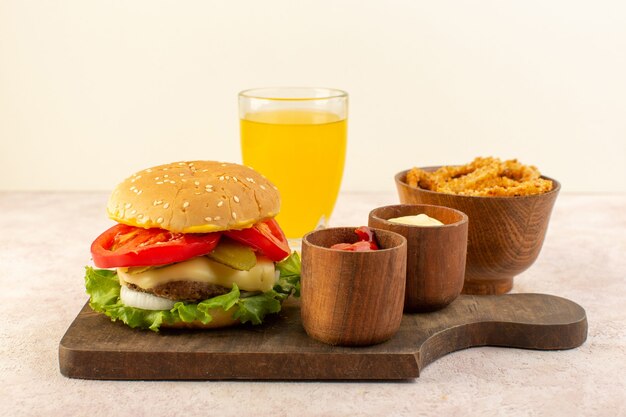 Une vue de face savoureux burger de viande avec du fromage et de la salade verte avec du ketchup et de la moutarde sur la table en bois