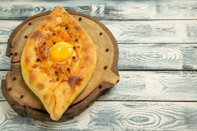 Vue de face savoureux pain aux œufs cuit sur le bureau rustique gris