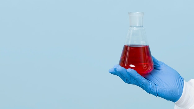 Photo gratuite vue de face scientifique tenant un produit chimique rouge avec espace de copie