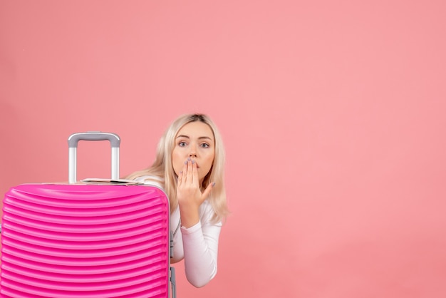 Vue de face se demandait belle femme debout derrière sa valise