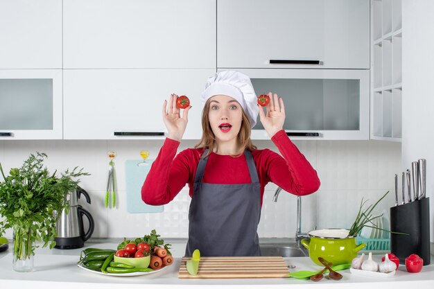 Vue de face se demandait une cuisinière en tablier tenant des tomates