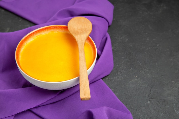 Vue de face simple soupe à la citrouille sur tissu violet et dîner de Thanksgiving sombre bureau lisse