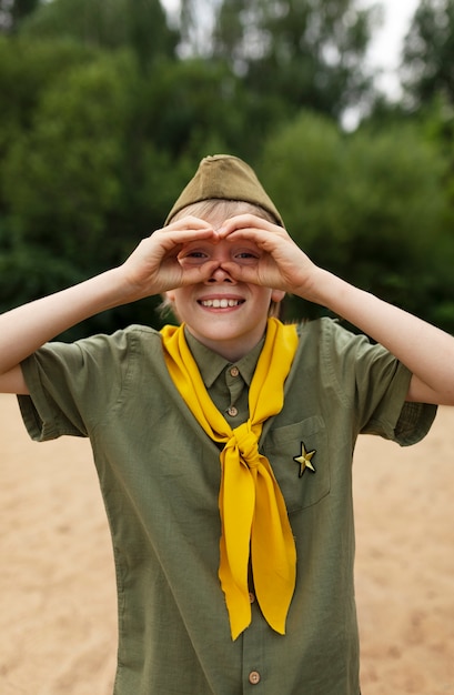 Photo gratuite vue de face smiley boy scout à l'extérieur