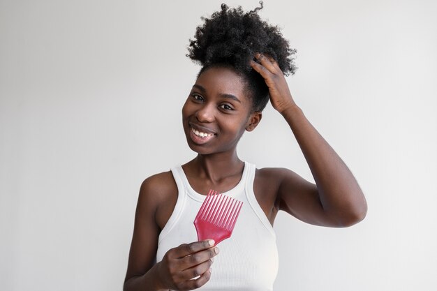 Vue de face smiley femme tenant un peigne rose