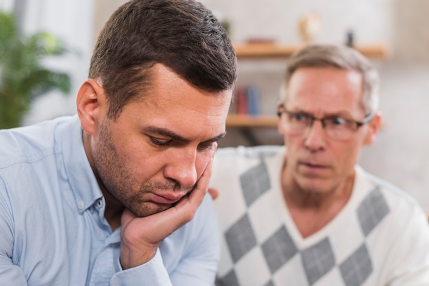 Vue de face de son fils triste et de son père