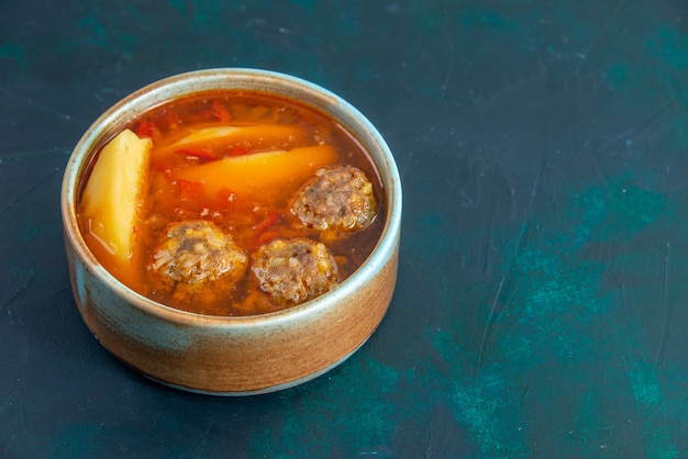 Vue de face de la soupe aux boulettes de viande avec pommes de terre à l'intérieur de la plaque ronde sur le bureau bleu foncé soupe alimentaire plat de viande de légumes