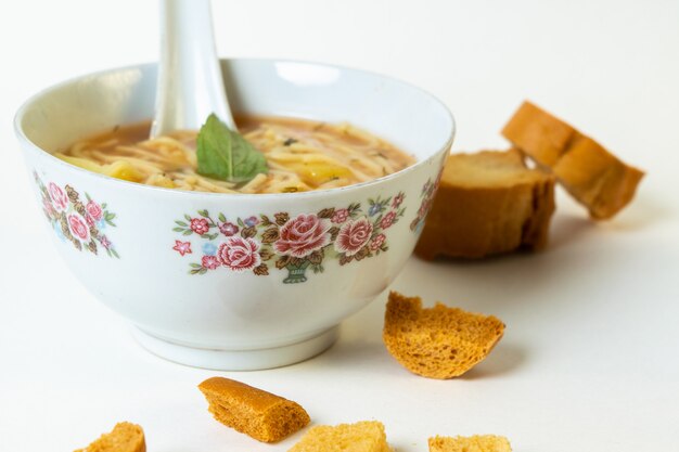 Une vue de face soupe chaude avec des légumes à l'intérieur des assiettes blanches avec des tranches de pain sur blanc