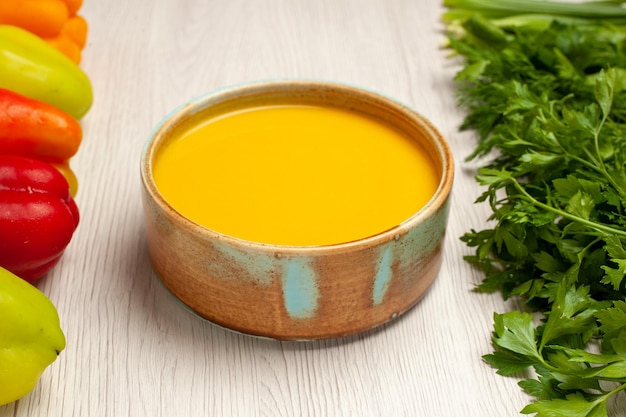 Vue de face soupe à la crème avec des légumes verts et des poivrons sur un bureau blanc soupe sauce crème dîner plat repas