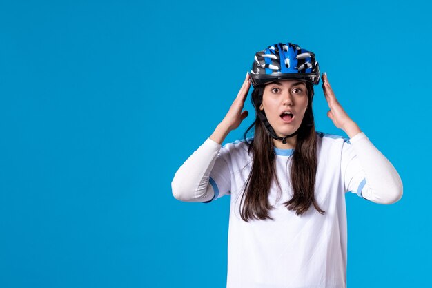 Vue de face surpris jeune femme en vêtements de sport avec casque