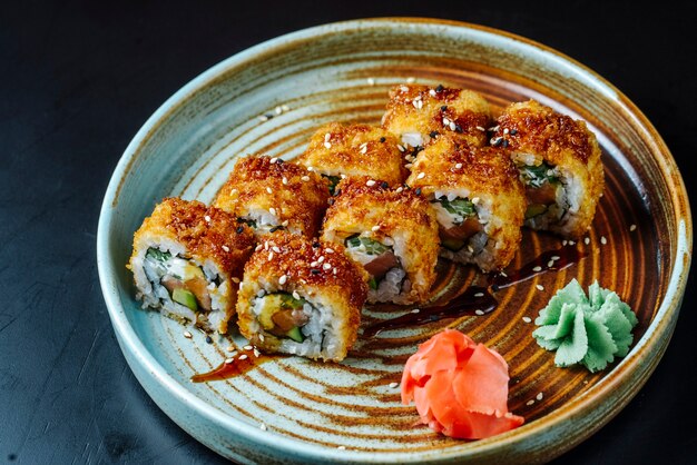 Vue de face sushi frit avec du poisson rouge avec wasabi et gingembre sur une assiette