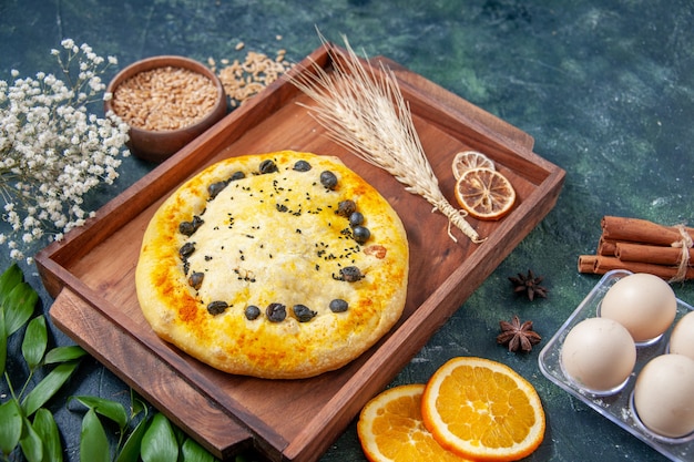 Vue de face tarte sucrée à l'intérieur d'un bureau en bois sur une surface bleu foncé