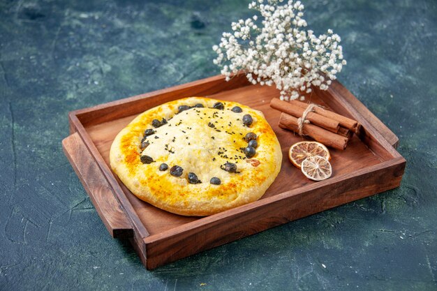 Vue de face tarte sucrée à l'intérieur d'un bureau en bois sur une surface bleu foncé