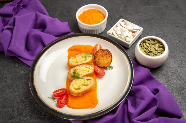 Vue de face des tartes aux pommes de terre en tranches avec de la citrouille en purée et des tomates sur fond gris